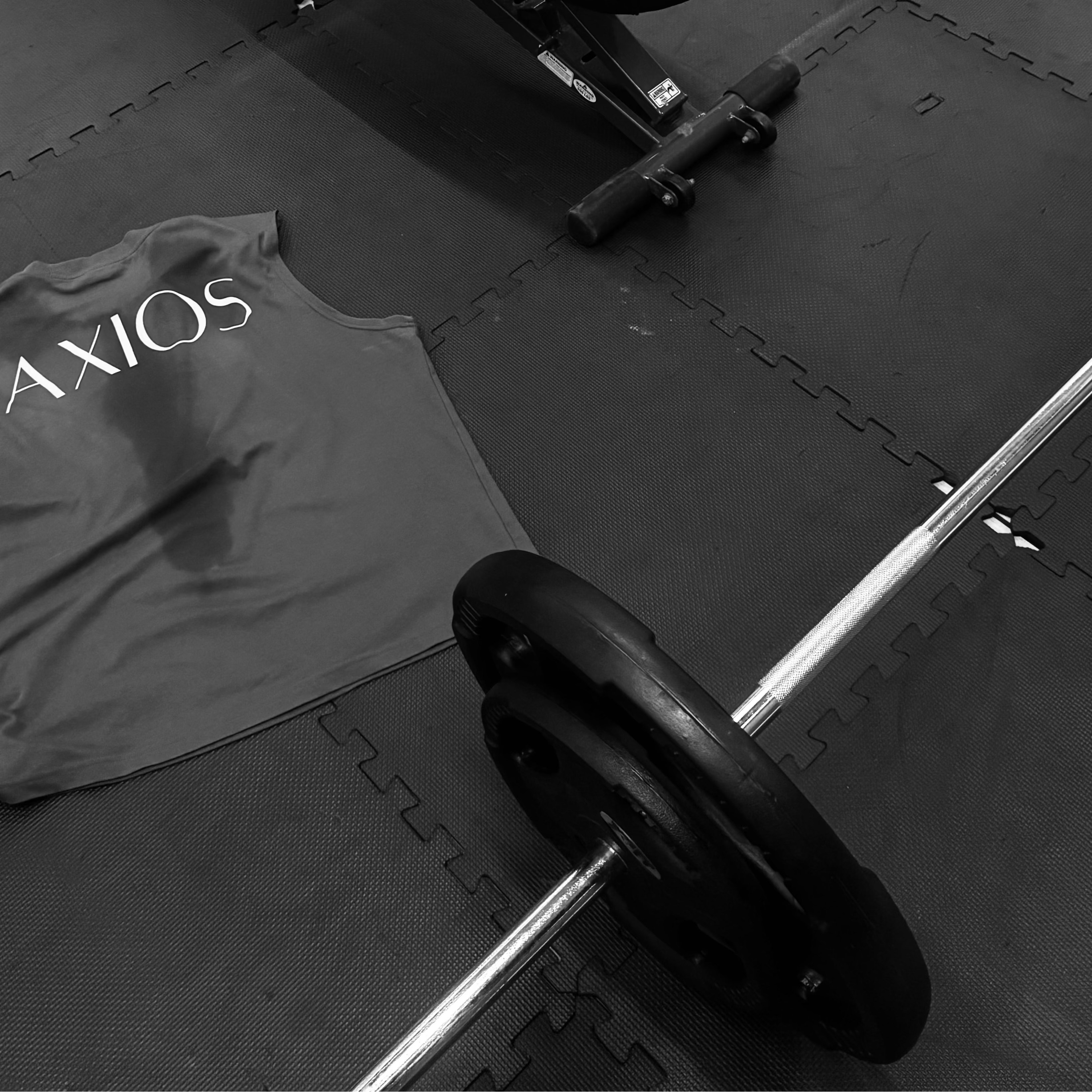 Gray tank top with 'AXIOS' branding on a gym floor with exercise equipment.